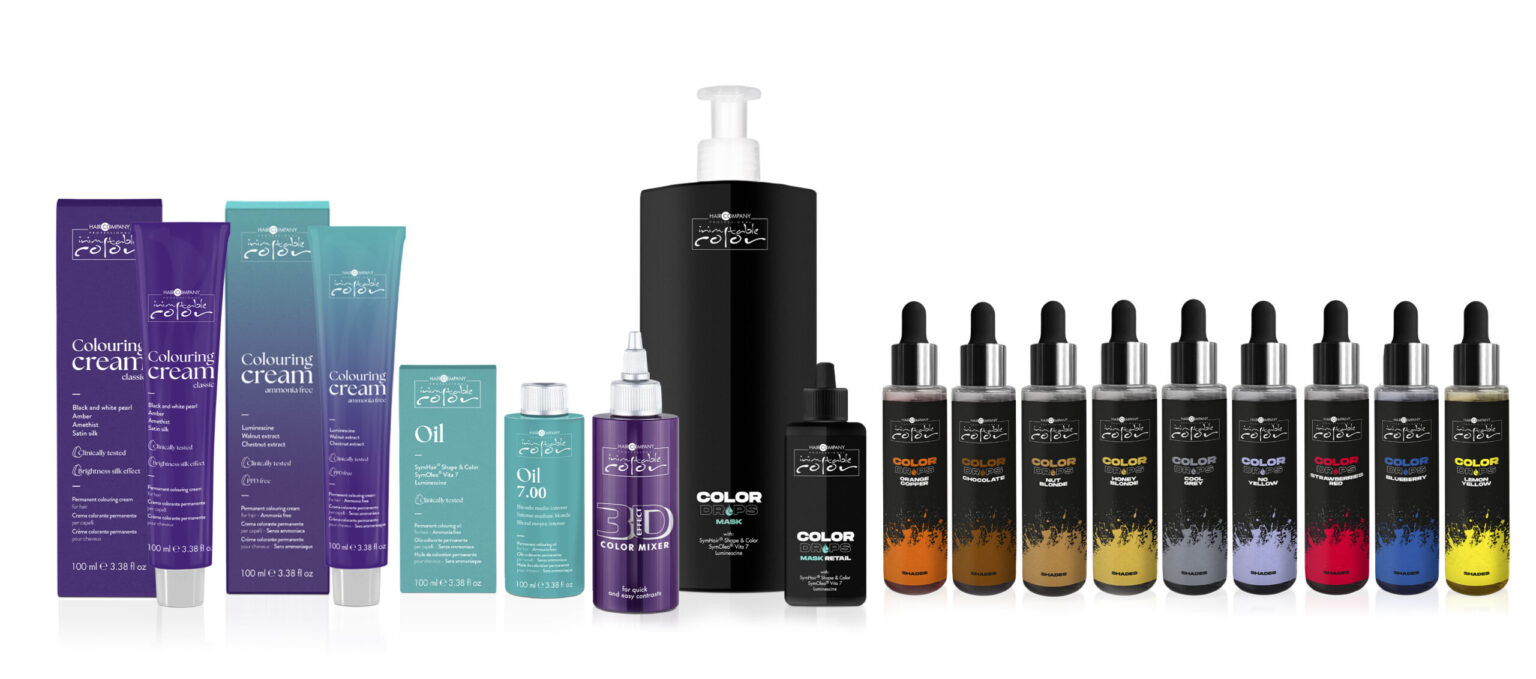 Image featuring a range of beauty products including color cream tubes, hair oil, scalp exfoliate, and various dropper bottles of inimitable color treatments. The packaging colors range from purples to blacks, and the products are neatly arranged in a row.